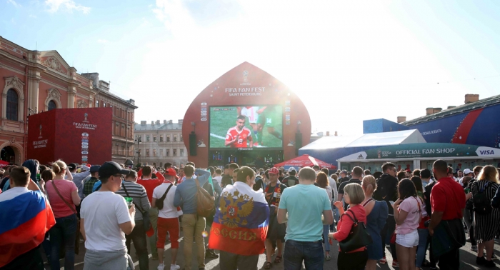 러시아월드컵이 개막한 14일(현지시간) 러시아 상트페테르부르크 네프스키대로 인근에서 축구팬들이 대형 화면을 통해 개막전 경기를 보고 있다. 뉴시스