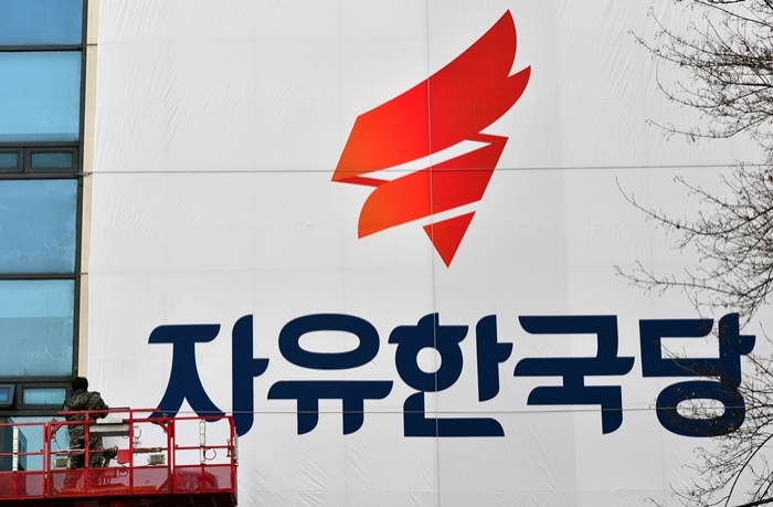 지난해 2월 ‘자유한국당’ 당명이 쓰인 현수막이 서울 여의도 한국당사에 설치되는 모습. 뉴시스