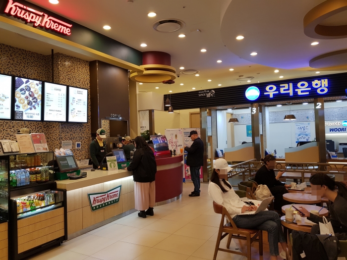 우리은행 롯데월드지점 내부 모습. 한쪽에선 도넛을 먹고, 다른 쪽에선 은행업을 보는 장면이 이색적이다.