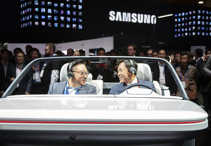 삼성전자 부스에서 웃으며 함께 '디지털 콕핏'을 체험하는 고동진 삼성전자 IM부문 사장과 박정호 SK텔렠콤 사장. SK텔레콤