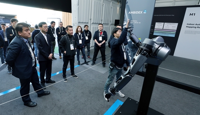 네이버 부스에 방문한 LG전자 관계자들이 브레인리스로봇 ‘앰비덱스’의 시연을 지켜보고 있다. 네이버