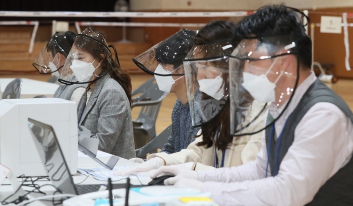 사회적 거리두기가 완화되고 있지만, 장기화에 대비한 체계확립이 필요하다. 제21대 국회의원 선거 사전 투표일을 하루 앞둔 9일 선거 사무원들이 비말 등을 막아주는 페이스마스크를 쓴채 투표시스템을 점검하고 있다.