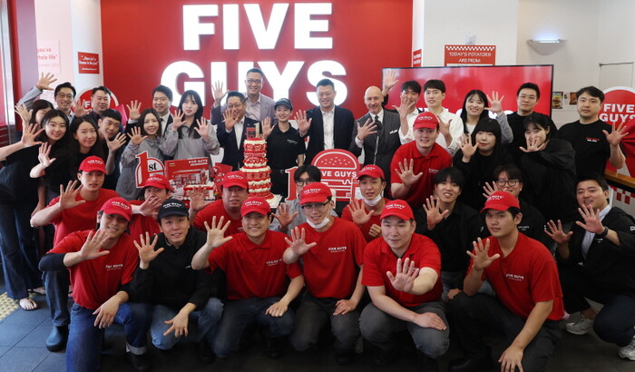 6월 26일 오전 서울 서초구 파이브가이즈 강남에서 열린 파이브가이즈 국내 오픈 1주년 기념 행사에서 임직원들이 관계자 및 직원들이 기념촬영을 하고 있다. 사진=뉴시스.