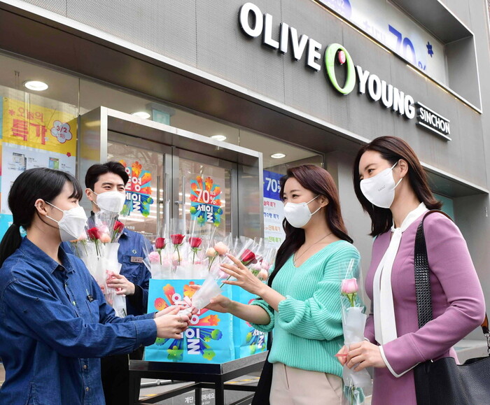 코로나19가 한창이던 2021년 3월. 서울 서대문구 연세로에 위치한 신촌 타운 매장에서 개강일을 맞아 등교하는 대학생들을 축하하며 장미꽃을 나눠주고 있는 올리브영 직원들. 사진=CJ올리브영 제공