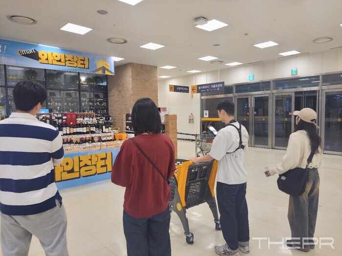 와인장터 행사 현장을 방문한 청년들. 우측 2번째 남성의 가슴 앞쪽에 촬영용 휴대전화가 고정되어 있다. 사진=김병주 기자.