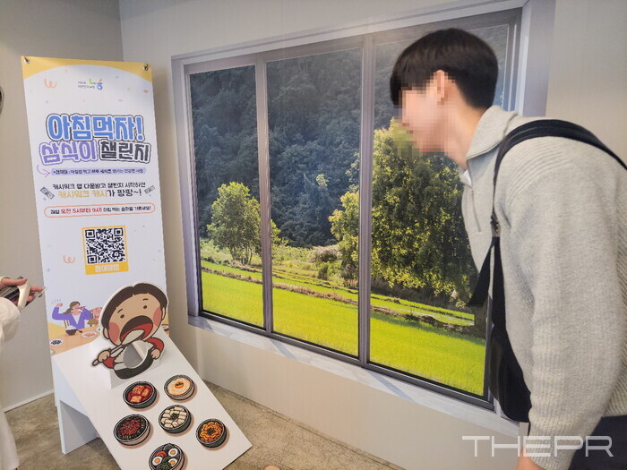 한 방문객이 '아침먹자! 삼식이 챌린지' 게임에 참여해 콩주머니를 던지려 하고 있다. 사진=김병주 기자.