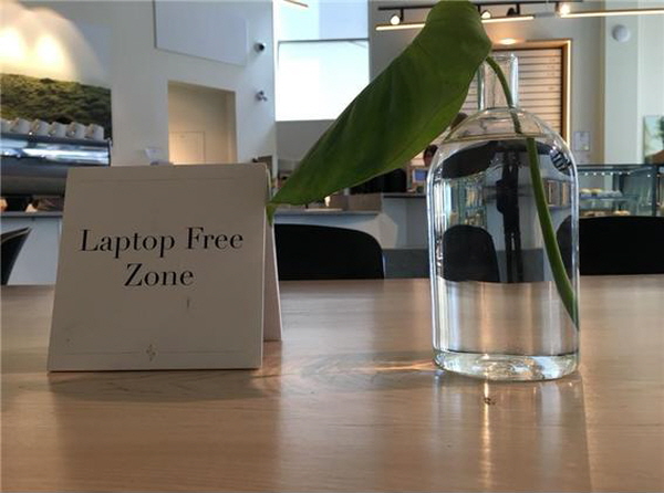 카페 내부 공용 테이블 한 곳은 일하는 사람에게 방해를 주지 않고 대화를 나누는 사람들은 일하는 사람의 눈치를 보지 않고 편하게 대화할 수 있는 랩탑프리 테이블. 이는 공동체 구성원 간 상호 배려를 위한 것이다. ©공공소통연구소