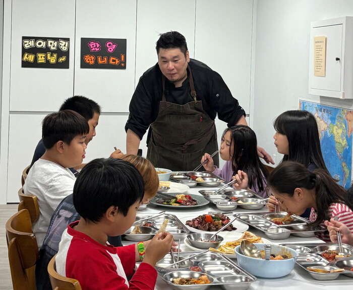 지난 10월, CJ나눔재단이 레이먼 킴 셰프 및 CJ프레시웨이와 협업하여 제작한 밀키트로 레이먼 킴 셰프가 직접 요리해 경기 평택 신정지역아동센터 아동에게 선보이고 있다. 사진=CJ나눔재단 제공.