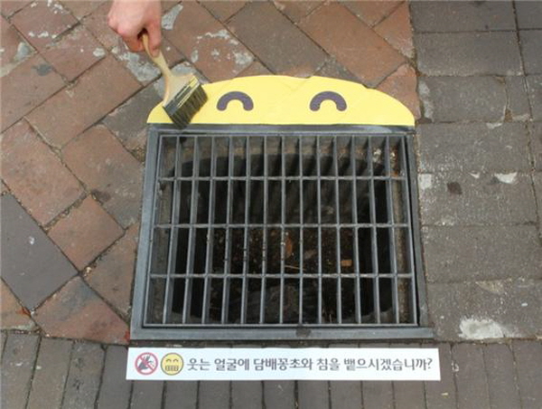 서울 시청 앞 주변에 시민의 반응을 관찰하기 위해 시범적으로 설치했던 빗물받이 스마일 스티커 예 ©공공소통연구소