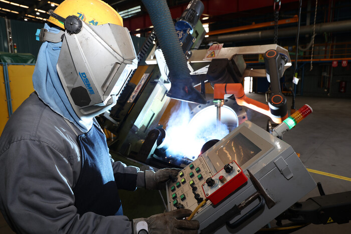 대우조선해양이 개발한 용접 협동로봇을 작업자가 조작하고 있다. 사진=대우조선해양 제공