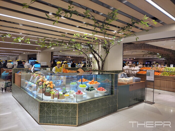 지난 5일 현대백화점 압구정본점 지하 식품관 계산대 옆에서 과일을 파는 모습. 사진=김병주 기자