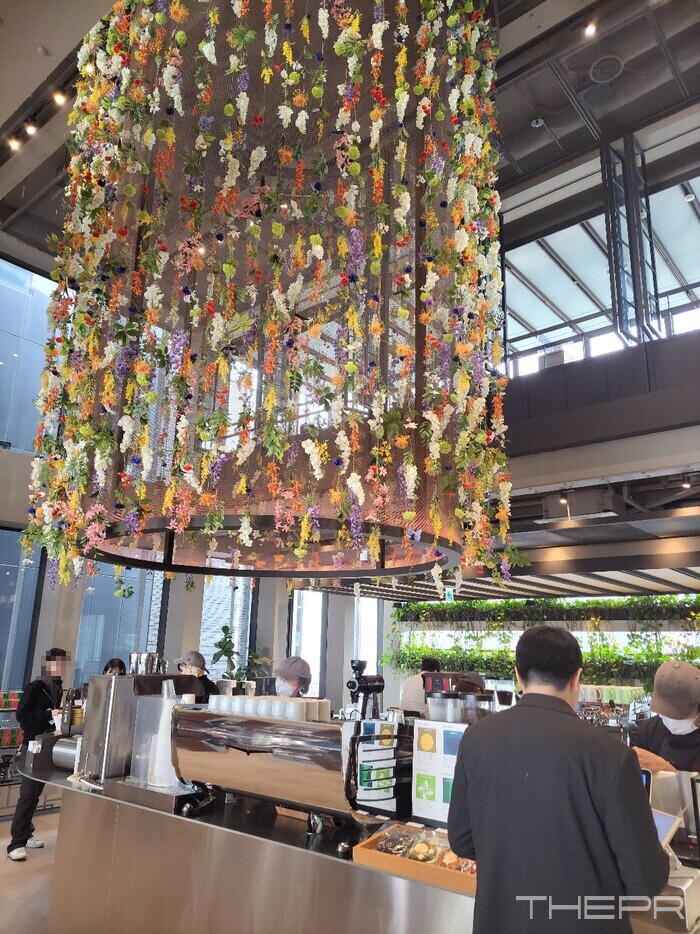 맥심플랜트 1층 주문 공간에 늘어뜨려진 천장 꽃 장식. 사진=김병주 기자
