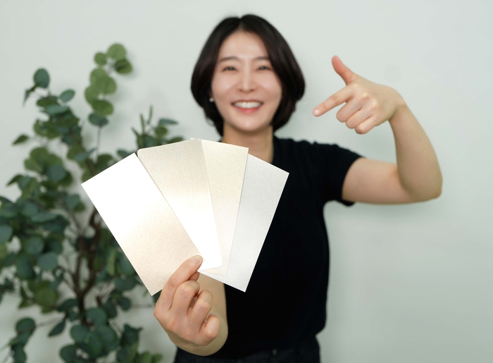 KCC 관계자가 실제 금속(왼쪽에서 두 번째)과 숲으로메탈릭을 칠한 종이(그 외 3개)를 비교하고 있다. 사진=KCC 제공