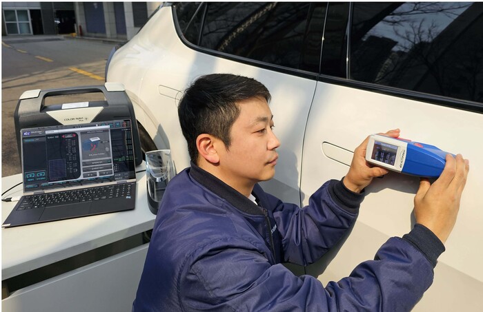 KCC 관계자가 칼라나비플러스(Color-Navi Plus)를 활용해 자동차 외장을 측색하며 테스트를 하고 있다. 사진=KCC 제공