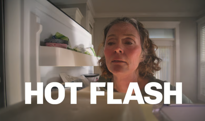 냉동고 문을 열고 열감을 식히고 있는 갱년기 여성 (사진 = 베오자의 2024 슈퍼볼 광고 컷)