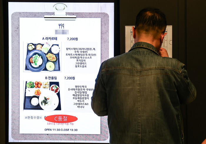 서울 시내 한 구내식당에서 점심식사를 하기 위해 한 직장인이 메뉴판을 보고 있다. 사진=뉴시스