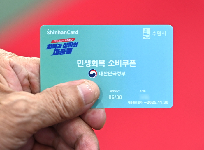 민생회복 소비쿠폰 2차 신청이 시작된 22일 경기 수원시 팔달구 인계동행정복지센터에서 한 시민이 선불카드를 수령받고 있다. 사진=뉴시스