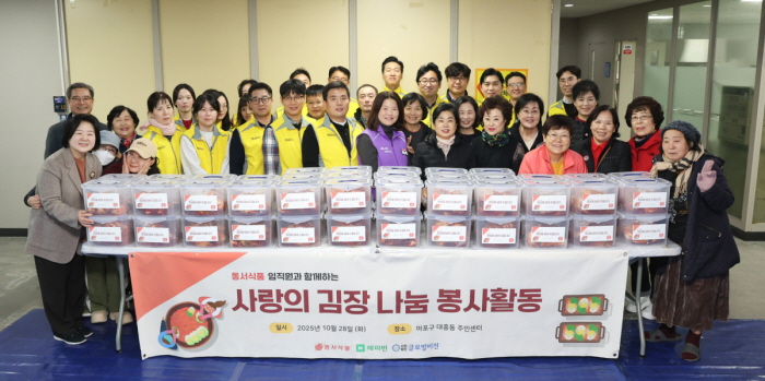 동서식품이 28일 서울시 마포구 대흥동주민센터에서 다문화·한부모 가정과 함께하는 김장 봉사활동을 진행했다. 봉사활동에 참여한 동서식품 직원들이 단체사진을 찍고 있다. 사진=동서식품